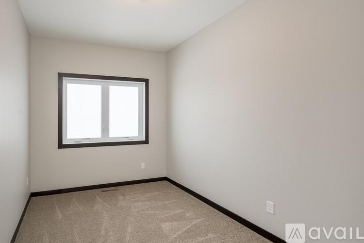 A room with a window and carpeted floor.