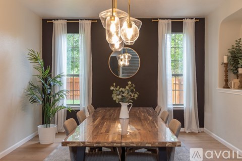 A dining room with a wooden table and chairs.