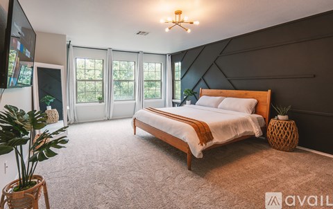 A bedroom with a large bed and a flat screen TV.
