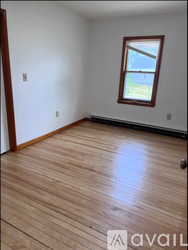 A room with wooden flooring and a window.
