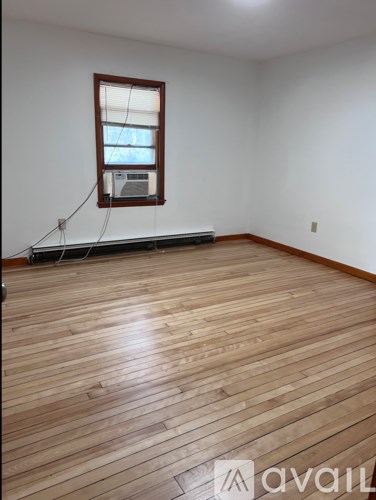 A room with wooden flooring and a window.
