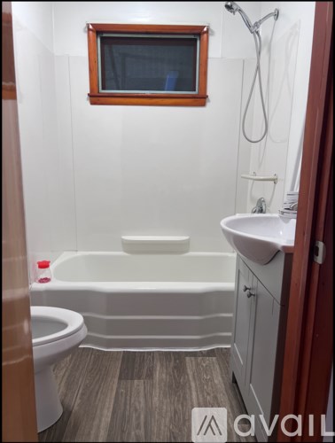 A bathroom with a white tub, toilet, and sink.