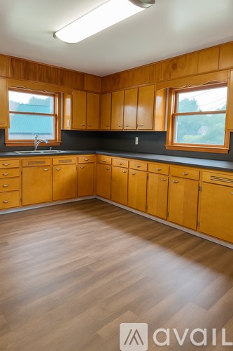 A kitchen with wooden cabinets and a black countertop.