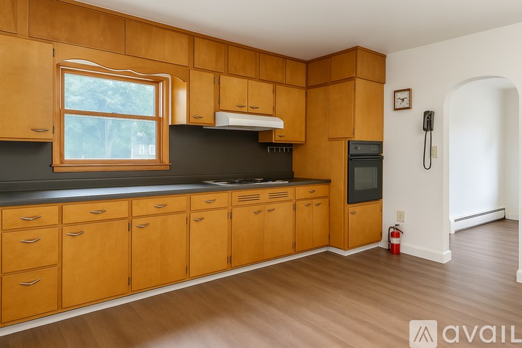 A kitchen with wooden cabinets and a black countertop.