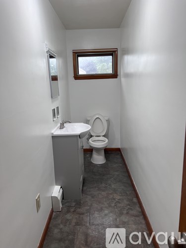 A bathroom with a toilet, sink, and mirror.
