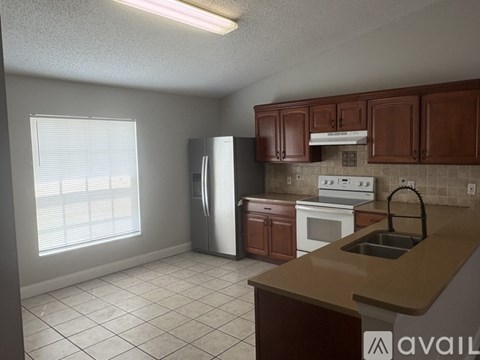 A kitchen with brown cabinets and a white refrigerator.