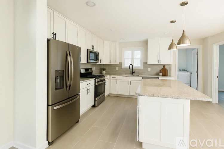 A kitchen with a refrigerator, microwave, and oven.