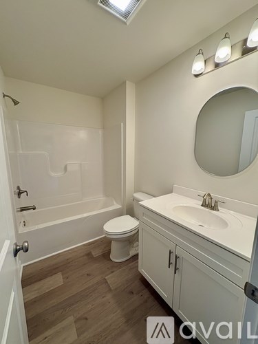 A bathroom with a toilet, sink, and bathtub.