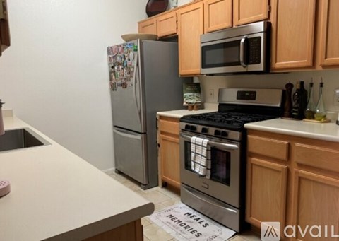 A kitchen with a refrigerator, stove, and microwave.