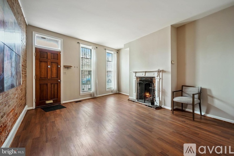 A room with a fireplace and a chair is available for rent.