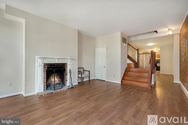 A living room with a fireplace and a staircase.