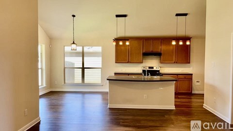 A kitchen with wooden cabinets and a white island.