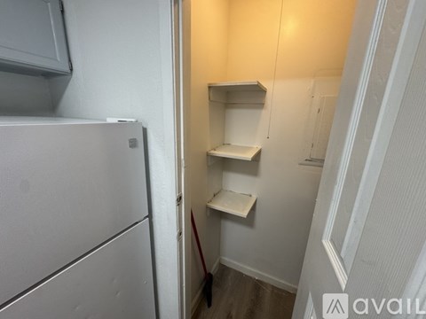 A small kitchen with a refrigerator and a cabinet.