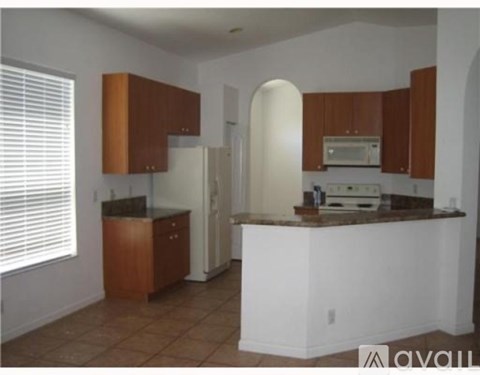 A kitchen with brown cabinets and a white refrigerator.
