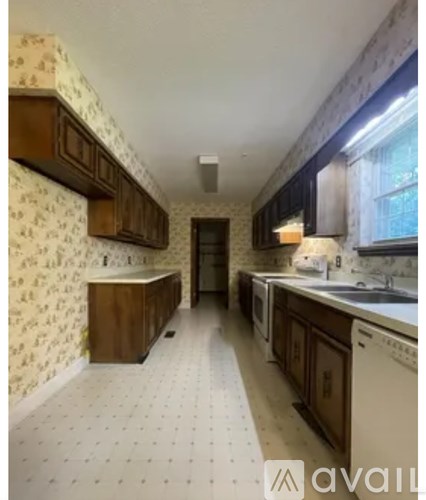 A kitchen with a white tile floor and wooden cabinets.