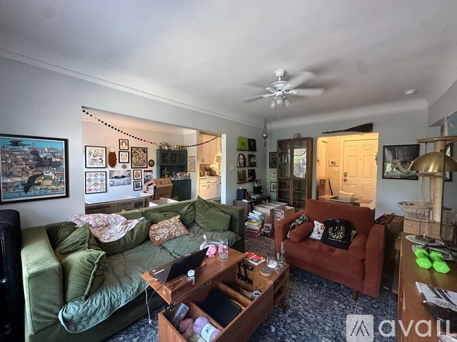 A living room with a green couch, a red couch, and a coffee table.