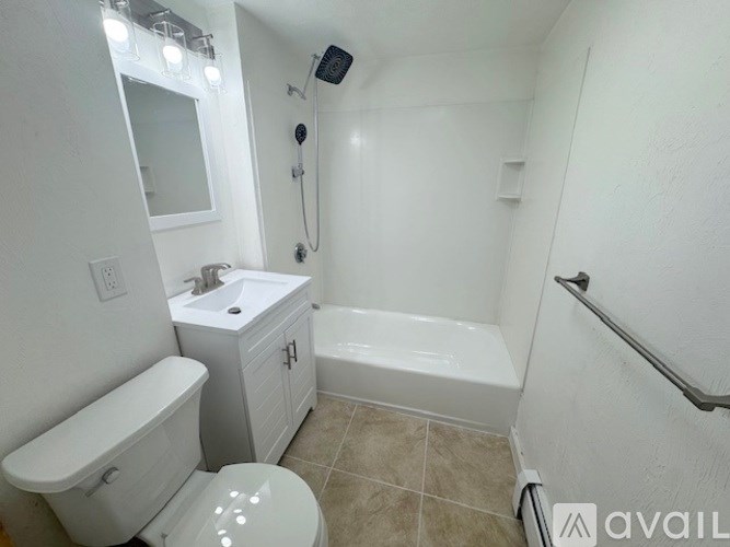 A white bathroom with a toilet, sink, and bathtub.