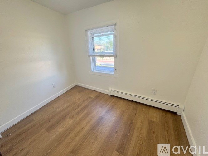 A room with wooden flooring and a window.