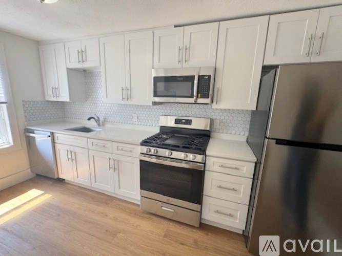 A kitchen with white cabinets and stainless steel appliances.