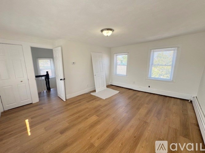 A room with wooden flooring and white walls is available for rent.