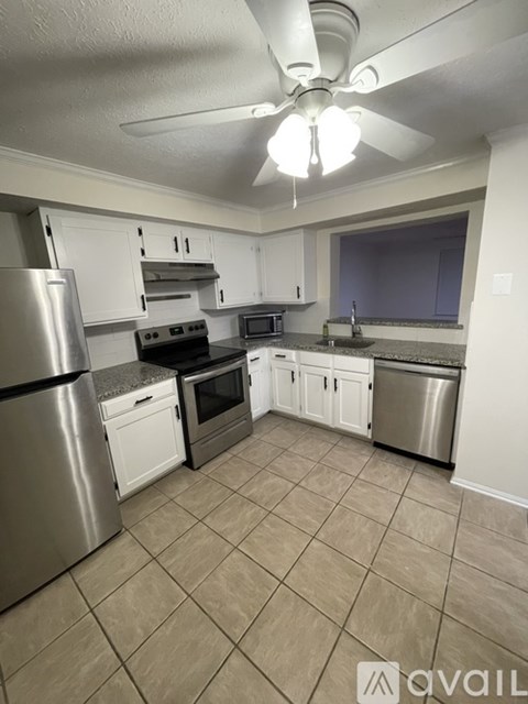 A kitchen with a refrigerator, oven, microwave, and sink.