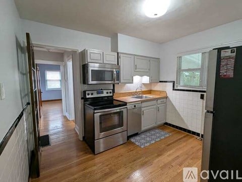 A kitchen with a stove top oven, microwave, and refrigerator.