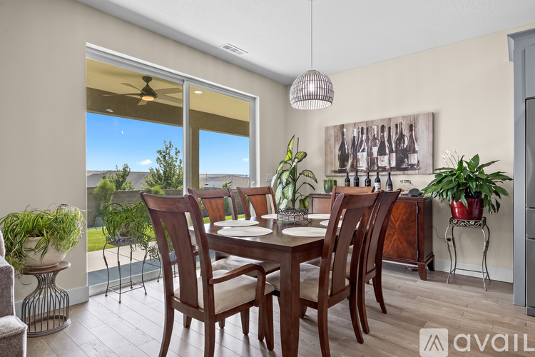 A dining room with a table set for four and a view of the outdoors.