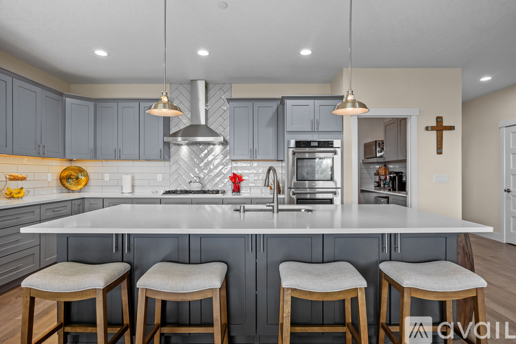 A kitchen with a large island and bar stools.