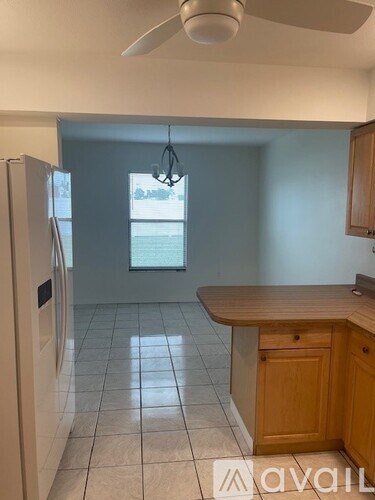 A kitchen with a wooden counter and a white fridge.