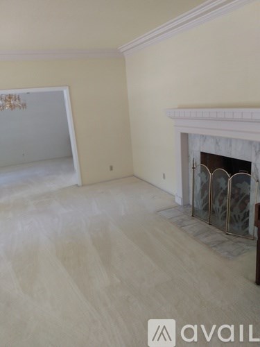 A room with a fireplace and a white wall.