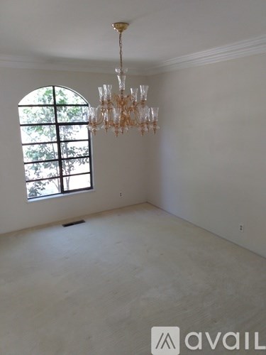 A room with a chandelier and a window.