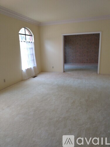 A room with a window and a wallpapered wall.