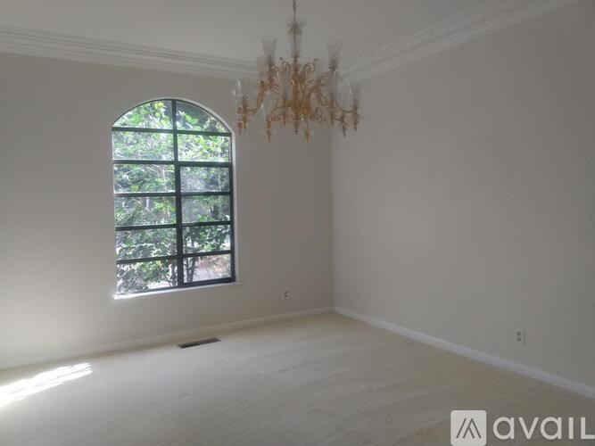 A room with a chandelier and a window.