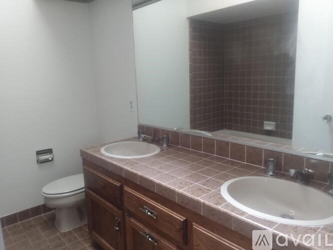 A bathroom with a toilet, sink, and mirror.