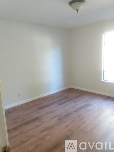 A room with wooden flooring and a window.