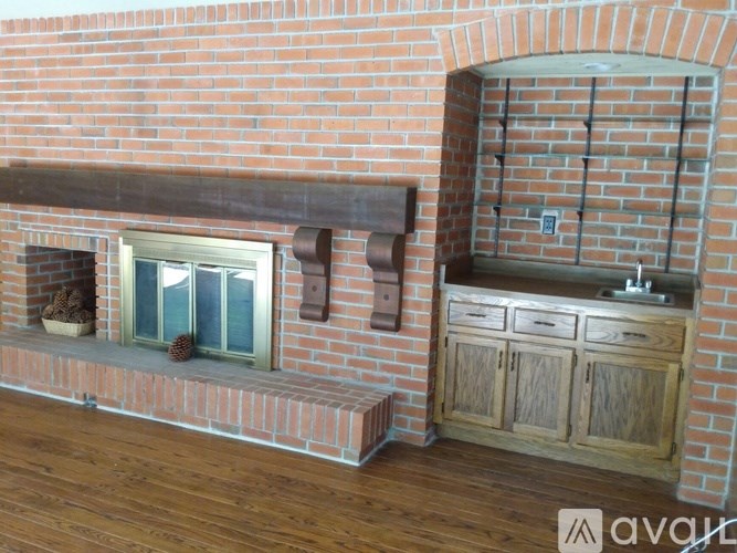 A brick wall with a window and a wooden cabinet.