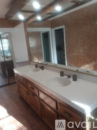 A bathroom with a large mirror and a sink.