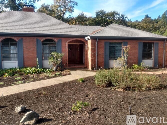 A red brick house with a brown door and windows.