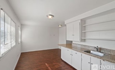 A kitchen with white appliances and wooden floors.