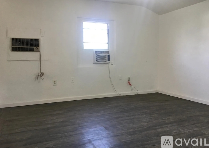 A room with wooden flooring and a window.