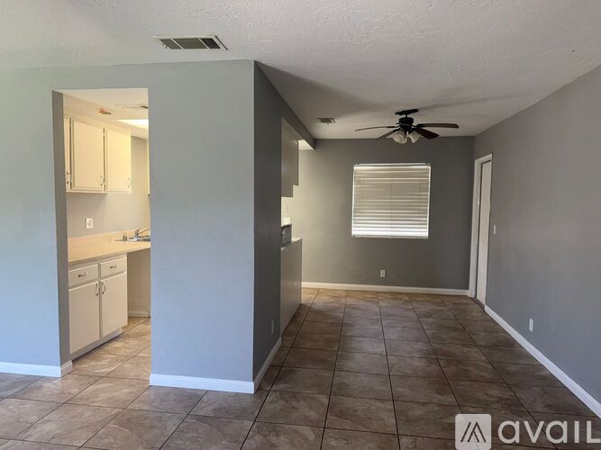 A room with a ceiling fan and tile flooring.