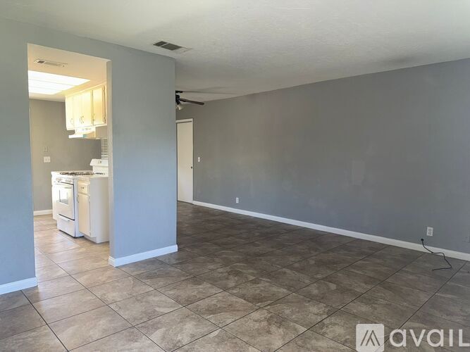 A kitchen area with a refrigerator, sink, and cabinets.