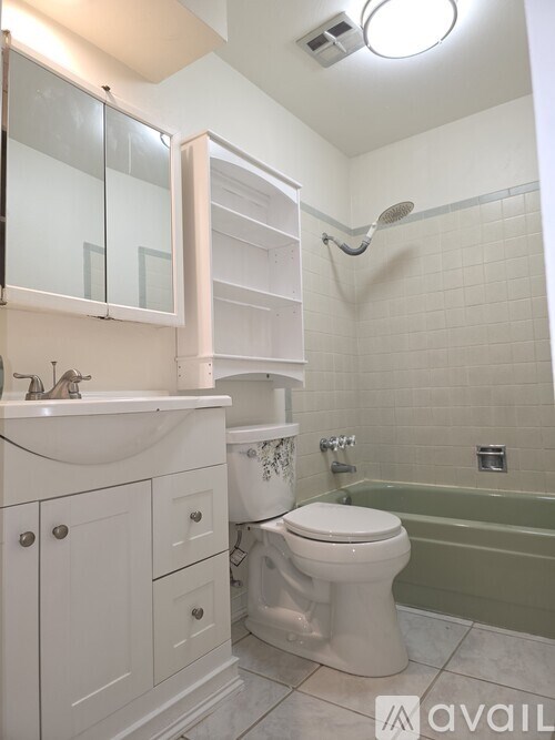 A white bathroom with a toilet, sink, and bathtub.