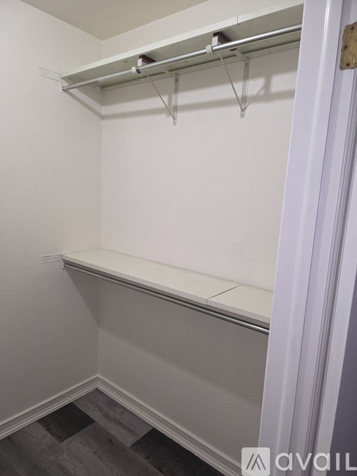 A white closet with a shelf and hanging space.