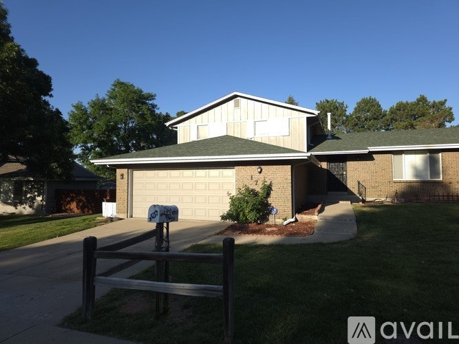 A house with a green lawn and a mailbox on the front.