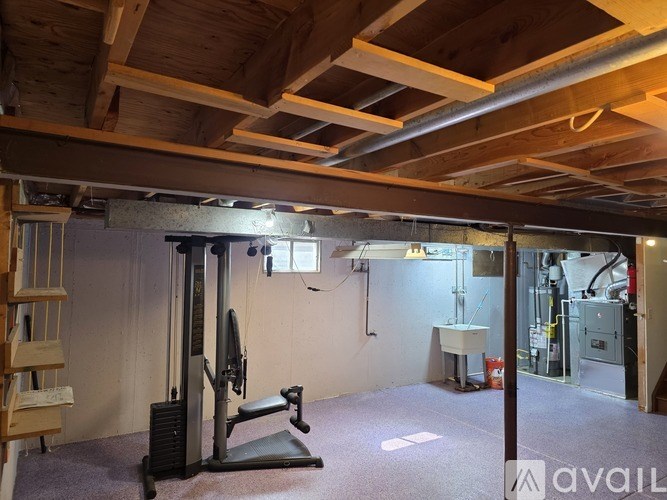 A room with a concrete floor and a white wall with a door on the right side.