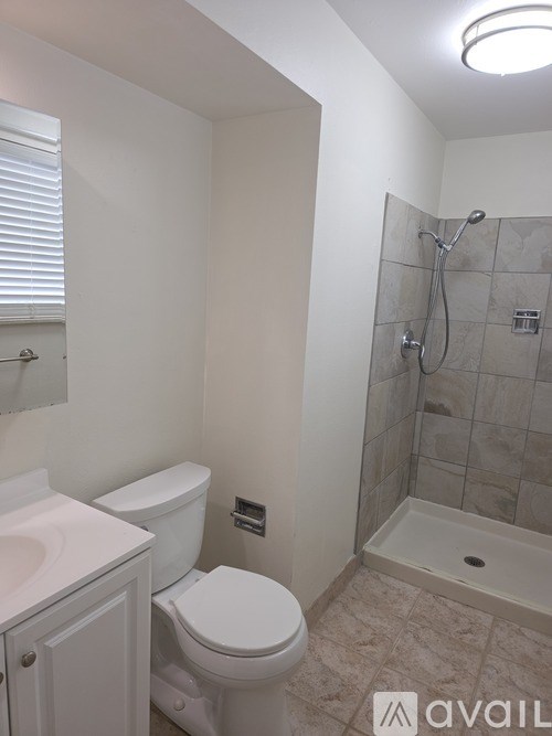A bathroom with a toilet, sink, and shower.