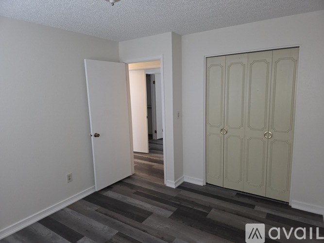 A white closet with a shelf and a door.