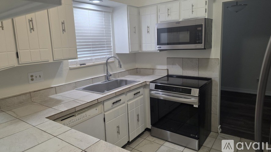 A kitchen with white cabinets and a black oven.