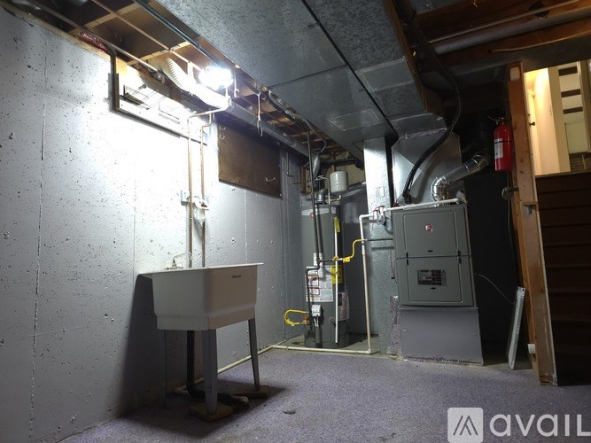 A room with a white sink and a grey electrical box.